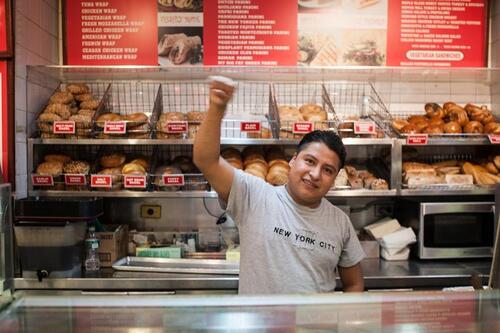 A scene from the film "The Hand That Feeds." Hot and Crusty pizza maker Nazario G. salutes the occupation of his workplace.